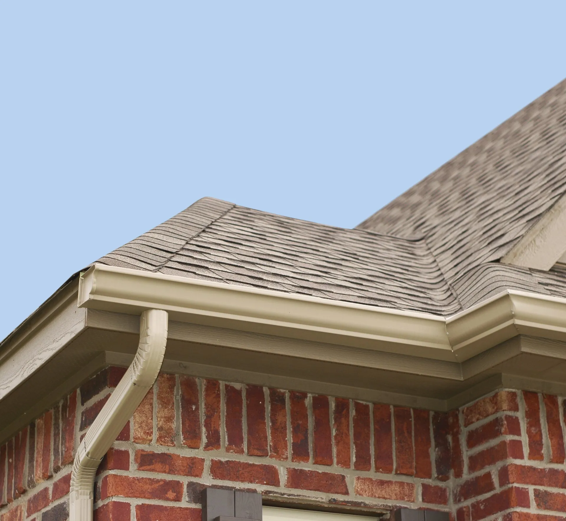 Residential gutter installed along a brick home